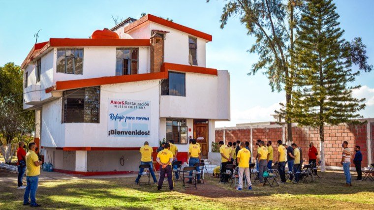 Fachada del refugio para varones, con la manta de bienvenida