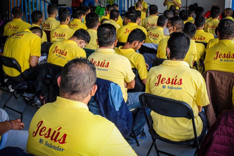 Residentes en oración durante un servicio en el refugio