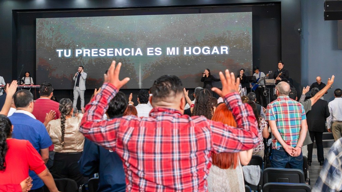 La congregación adorando con las manos alzadas